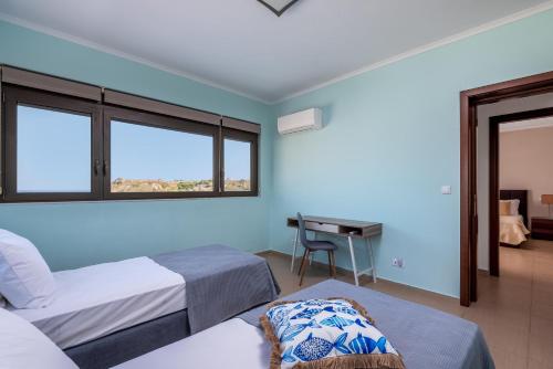 a room with two beds and a desk in it at Acro Villa in Afantou