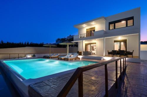 a villa with a swimming pool at night at Acro Villa in Afantou