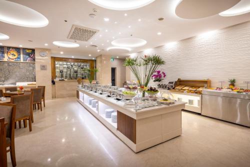 a buffet line in a restaurant with tables and chairs at Eden Star Saigon Hotel in Ho Chi Minh City