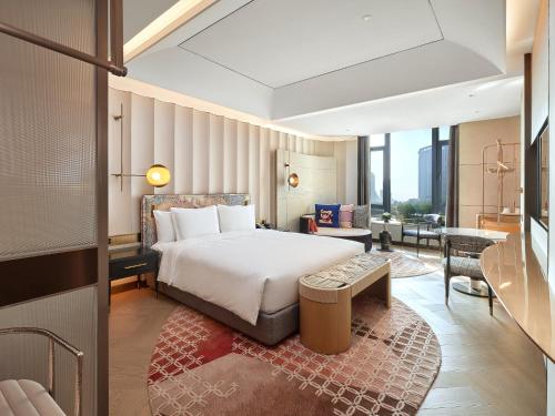 a bedroom with a bed and a living room at Hotel Indigo Xiamen Haicang, an IHG Hotel-First Day Free Mini Bar in Xiamen