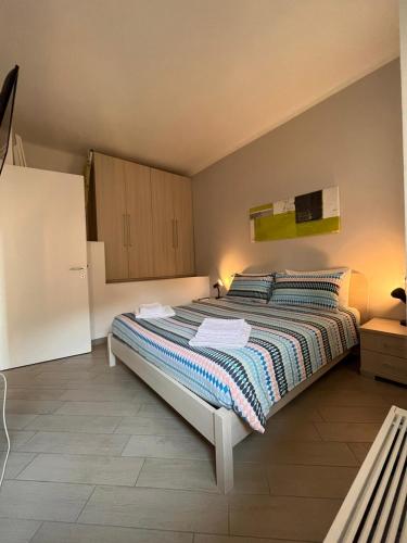 a bedroom with a large bed and a refrigerator at BelSorrisoVarese - Elegance City Residence Private Parking -Reservation Required- in Varese