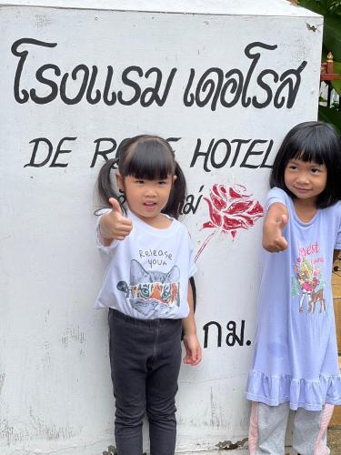 two little girls standing in front of a sign at DE ROSE Hotel Chiang Mai in Chiang Mai