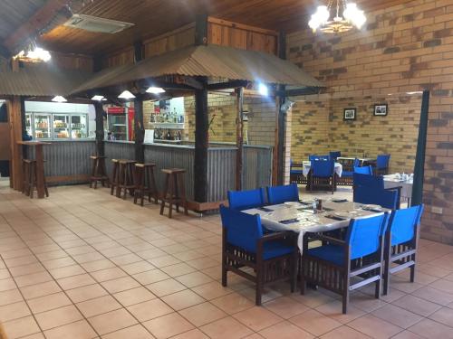 un restaurante con mesa y sillas y un bar en Boulder Opal Motor Inn, en Winton