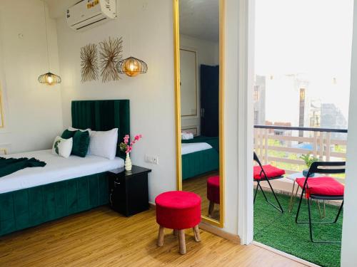 BluO Studio Noida - BathTub, Gym, Balcony, Garden في نويدا: غرفة نوم بسرير ومرآة وشرفة