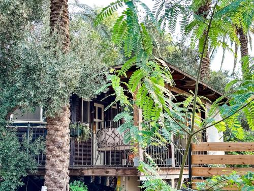 a house with a balcony in the middle of trees at Crimson View in Moshav Ramot