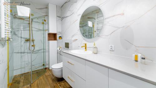 a white bathroom with a sink and a mirror at Wonder Home - Apartamenty blisko centrum, tuż przy kolei gondolowej i trasach Single Track in Świeradów-Zdrój