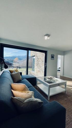 a living room with a blue couch and a glass table at Mountain Lodge in Râşnov