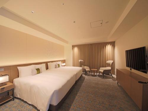 a hotel room with a large bed and a flat screen tv at TOKYO EAST SIDE HOTEL KAIE in Tokyo