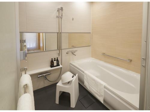a bathroom with a white tub and a white stool at TOKYO EAST SIDE HOTEL KAIE in Tokyo