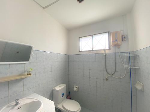 uma casa de banho com um WC, um chuveiro e um lavatório. em Karon House 15B em Praia de Karon