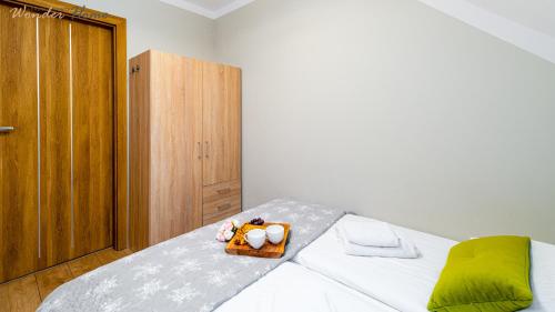 a bedroom with a bed with a purse on it at Wonder Home - Apartamenty położone blisko deptaka, licznych restauracji i sklepów in Karpacz