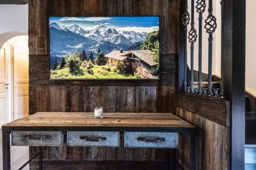 a painting of a mountain view on a wall at Ein JUWEL "zum-Auerhahn" in Modriach