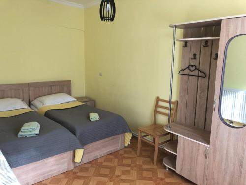 a bedroom with two beds and a mirror at Inga Jafaridze Guesthouse Pele in Mestia