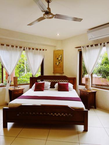 a bedroom with a large bed in a room with windows at Biancas Garden Apartments Boracay in Boracay