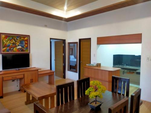 a living room with a dining table and a television at Nest Resort in Pagudpud