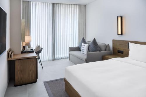 a hotel room with a bed and a couch at Radisson Beach Resort Palm Jumeirah in Dubai