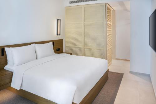 a bedroom with a white bed and a window at Radisson Beach Resort Palm Jumeirah in Dubai