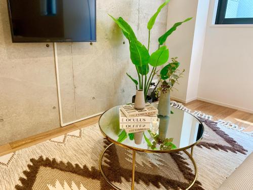 a glass table with a plant on top of it at Ken's Place四谷 in Tokyo