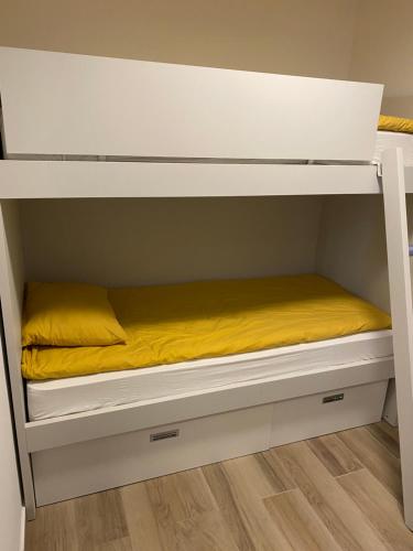 a bunk bed with a yellow blanket on it at Golte Apartment Tibona in Mozirje
