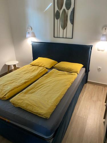 a bed with yellow sheets on it in a room at Golte Apartment Tibona in Mozirje