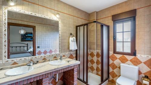 a bathroom with two sinks and a shower at Cortijo Barranco Hondo Íllora by Ruralidays in Illora
