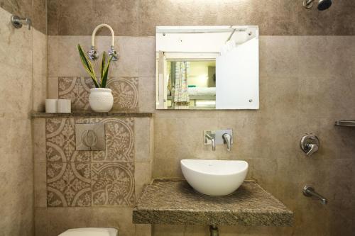 a bathroom with a sink and a toilet and a mirror at Moustache Hostel, Jaipur in Jaipur
