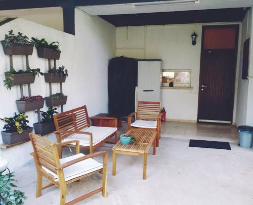 two chairs and a table in a room with plants at לטייל בחוץ להרגיש בבית in H̱efẕi Bah
