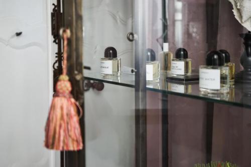 a display case with many perfume bottles on it at Hôtel Particulier Le 28 - Spa & Art Luxury Design by Alain Ducasse in Aix-en-Provence
