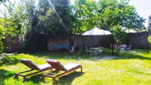 une cour avec deux chaises et un gazebo dans l'établissement Les Salamandres, chambres d'hôtes près de Chambord, à Montlivault