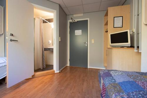 a bedroom with a bed and a television in it at Kongsberg Hostel-Vandrerhjem in Kongsberg