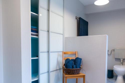 uma casa de banho com uma cesta de toalhas azuis numa cadeira em Spękane Skały - Apartament em Miszkowice