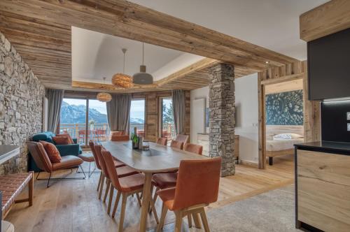 une salle à manger et un salon avec une table et des chaises dans l'établissement Appartement Panorama, résidence Les Alpages, à Montvalezan