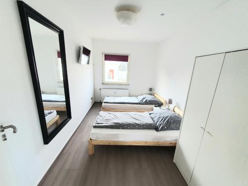 een slaapkamer met 2 bedden en een spiegel bij Pottmensch Oberhausen in Oberhausen
