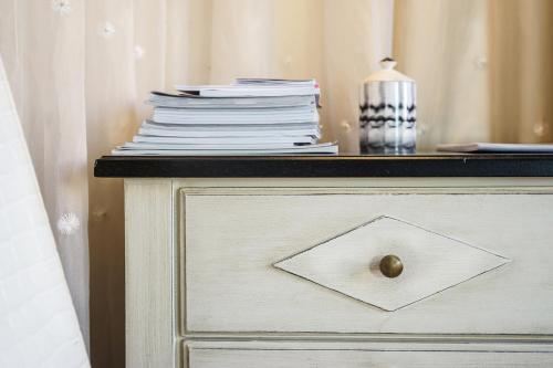 a stack of books on top of a dresser at Hôtel Particulier Le 28 - Spa & Art Luxury Design by Alain Ducasse in Aix-en-Provence