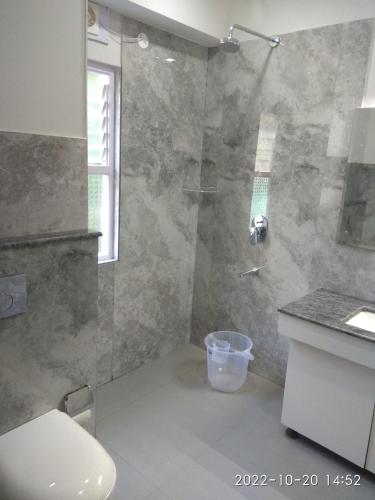 a bathroom with a shower with a toilet and a sink at Golden Peaks Hotel & Restaurant in Kalimpong