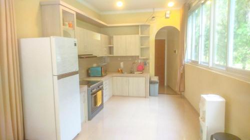 a kitchen with a white refrigerator and a window at Villa London Puncak in Sampal 2