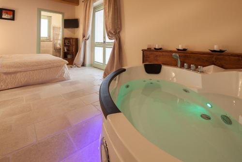 a bathroom with a bath tub in a room at Le Maraclà Country House in Iesi