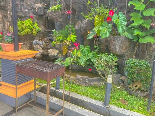a garden with a table and some plants and flowers at Villa London Puncak in Sampal 2