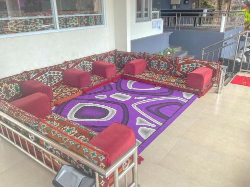 a room with a couch and chairs on a carpet at Villa London Puncak in Sampal 2