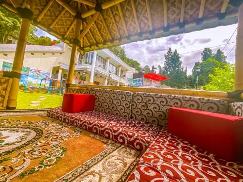 a room with two red chairs and a large window at Villa London Puncak in Sampal 2