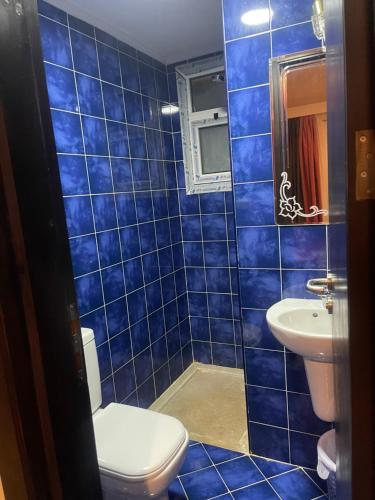een blauw betegelde badkamer met een toilet en een wastafel bij Apartment in Porto sharm in Sharm El Sheikh