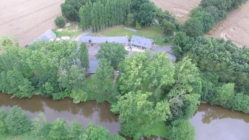 an aerial view of a house in the middle of a river at Le gîte de l'Ecurie in Forges-la-Forêt