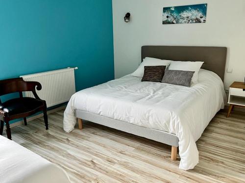 a bedroom with a large bed and a chair at Le parc de Gouts in Aiguillon