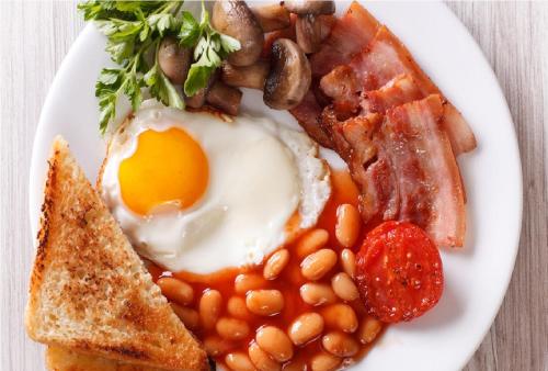 a plate of breakfast food with eggs bacon beans and toast at East Pallant Bed and Breakfast, Chichester in Chichester