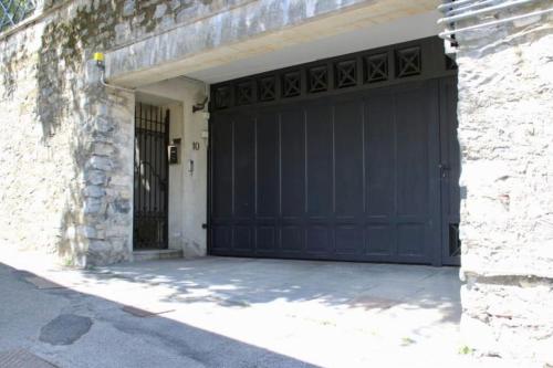 a garage with a black garage door on a building at Charming & Luxury Villa Como Lake in Como