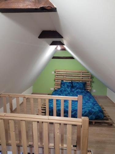 um quarto com uma cama azul num sótão em Maisonette em Muret-le-Château