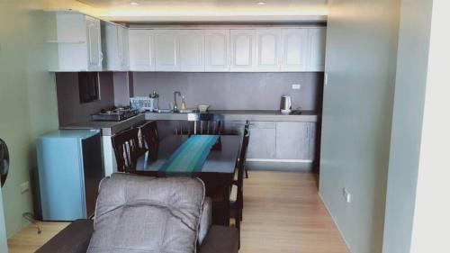 een keuken met een tafel en stoelen in een kamer bij Avana Hills Boracay Prime Family Suite in Boracay