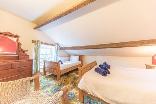 a bedroom with two beds and a dresser at 1 Dixon Ground Coniston in Coniston