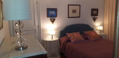 1 dormitorio con 1 cama con lámpara y 2 mesas en CASABELLA, en Senise