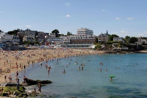 un grupo de personas en una playa en el agua en Maison au calme et proximité plage. en Saint-Quay-Portrieux